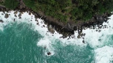 Deniz kıyısındaki kayalara çarpan dalgaların hava görüntüsü Rocky sahili muhteşem doğa arka planı Phuket adası
