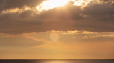 Deniz üzerinde şaşırtıcı bulutlar Zaman ve Günbatımı veya gündoğumu Yanan altın gökyüzü ve parlayan altın dalgalar Deniz yüzeyinde güzel ışık yansıması 4K görüntüler Zaman Hızı 'nın muhteşem ışığı
