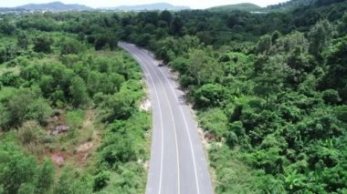 Hava alçak uçuş yolu üzerinde mükemmel asfalt yol ve güneşli yaz mevsiminde yeşil ağaçların yakınında çayır.