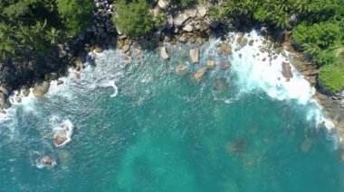 Dev okyanus dalgalarının kayalara çarpıp köpürdüğü inanılmaz deniz kıyısı manzarası. Tayland 'daki Phuket Adası' nda kayalara çarpan okyanus dalgalarının kuş bakışı görüntüsü