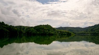Yağmur ormanları dağı ve göl mavi gökyüzünde akan bulutlar suya yansıyor Zaman Hızı 4K