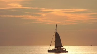 Tropikal denizde güzel bir günbatımında yelkenli ya da su yüzeyinde yansıyan güneşle gündoğumu göğünde yelken aç. Phuket Adası 'nda gün batımı Tayland Yazı ve seyahat tatili konsepti