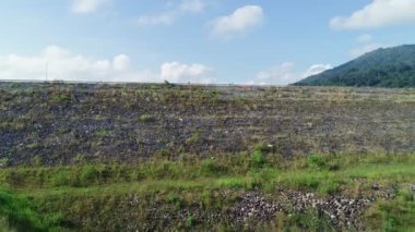 Kuru toprak ve orman yeşili desenli Dam Gölü Dağları 'nın havadan görünüşü güzel güneşli yaz havası İHA hava görüntüsü bulutları sulama çevresi