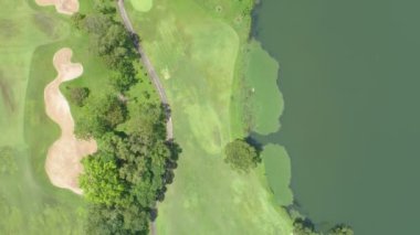 Golf sahasının havadan görünüşü yeşil çimenleri ve ağaçları golf sahasına koyuyor ve yeşil üst manzarayı yaz güneşli günlerinde golf sahalarının üzerine koyuyor.