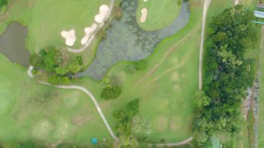 Golf sahasının havadan görünüşü yeşil çimenleri ve ağaçları golf sahasına koyuyor ve yeşil üst manzarayı yaz güneşli günlerinde golf sahalarının üzerine koyuyor.