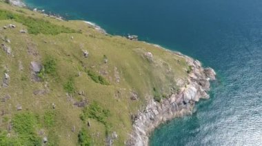 Mavi okyanusta yukarıdan tropikal deniz manzarası ve inanılmaz dağ kayaları. Güzel deniz yüzeyi hava aracı görüntüsü, yüksek açılı deniz manzarası.