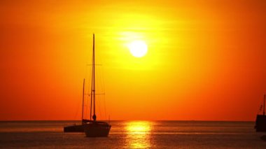 Tropikal denizde güzel bir günbatımında yelkenli ya da su yüzeyinde yansıyan güneşle gündoğumu göğünde yelken aç. Phuket Adası 'nda okyanus üzerinde gün batımı Tayland' da inanılmaz deniz akşamı karanlık gökyüzü