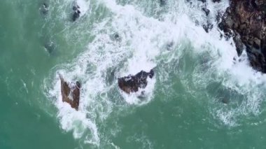 Okyanustaki deniz kıyısındaki kayaların tepesindeki insansız hava aracı kamerası. Güzel deniz yüzeyi. İnanılmaz deniz dalgaları Phuket Adası 'ndaki deniz manzaralı kayalara çarpıyor.