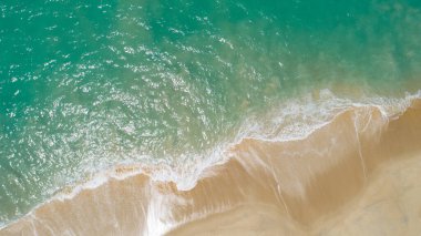 Hava manzaralı kumlu sahil ve kumlu sahile çarpan dalgalar yaz mevsiminde güzel tropikal deniz görüntüsü Aerial view drone çekimi, yukarıdan aşağıya yüksek açılı görüntü
