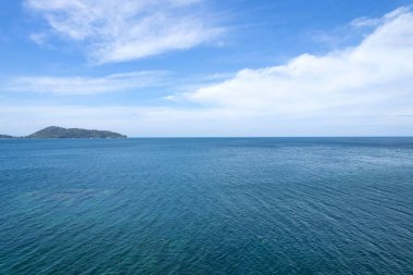 Mavi deniz yüzeyinin hava görüntüsü su dokusu arka plan ve gökyüzü beyaz bulutlar uçan dron görüntüsü Phuket Adası Tayland 'daki güneşli tropikal okyanusta su yüzeyi dokusu dalgaları