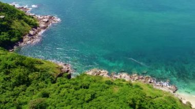 Okyanustaki deniz kıyısı kayalarının insansız hava aracı kamerası. Güzel karanlık deniz yüzeyi. Tayland 'ın Phuket adasında kayalıklara çarpan inanılmaz deniz dalgaları. Hava gözlem dronu 4k Yüksek kalite görüntü