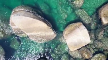 Okyanustaki deniz kıyısı kayalarının insansız hava aracı kamerası. Güzel karanlık deniz yüzeyi. Tayland 'ın Phuket adasında kayalıklara çarpan inanılmaz deniz dalgaları. Hava gözlem dronu 4k Yüksek kalite görüntü