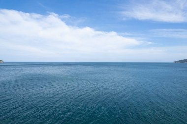 Mavi deniz yüzeyinin hava görüntüsü su dokusu arka plan ve gökyüzü beyaz bulutlar uçan dron görüntüsü Phuket Adası Tayland 'daki güneşli tropikal okyanusta su yüzeyi dokusu dalgaları