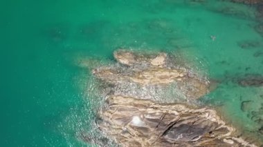 Okyanustaki deniz kıyısındaki kayaların tepesindeki insansız hava aracı kamerası. Güzel deniz yüzeyi. İnanılmaz deniz dalgaları Phuket Adası 'ndaki deniz manzaralı kayalara çarpıyor.