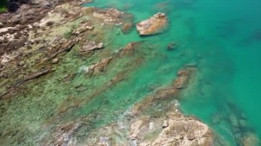Okyanustaki deniz kıyısındaki kayaların tepesindeki insansız hava aracı kamerası. Güzel deniz yüzeyi. İnanılmaz deniz dalgaları Phuket Adası 'ndaki deniz manzaralı kayalara çarpıyor.