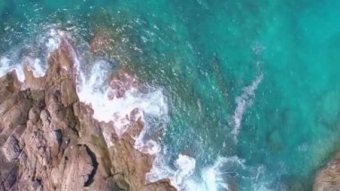 Okyanustaki deniz kıyısı kayalarının insansız hava aracı kamerası. Güzel deniz yüzeyi. Tayland 'ın Phuket adasında kayalıklara çarpan inanılmaz deniz dalgaları. Hava gözlem dronu 4k Yüksek kalite görüntü