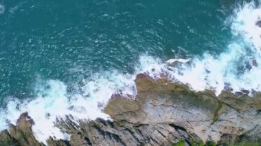 Okyanustaki deniz kıyısı kayalarının insansız hava aracı kamerası. Güzel deniz yüzeyi. Tayland 'ın Phuket adasında kayalıklara çarpan inanılmaz deniz dalgaları. Hava gözlem dronu 4k Yüksek kalite görüntü