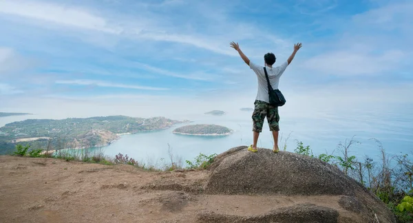 Alone happy man photographer or traveler standing and thinking something and see beautiful scenery landscape nature view on rock mountain in phuket thailand