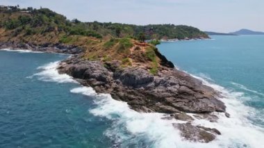 Okyanustaki deniz kıyısı kayalarının insansız hava aracı kamerası. Güzel deniz yüzeyi. Tayland 'ın Phuket adasında kayalıklara çarpan inanılmaz deniz dalgaları. Hava gözlem dronu 4k Yüksek kalite görüntü