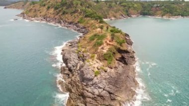 Okyanustaki deniz kıyısı kayalarının insansız hava aracı kamerası. Güzel deniz yüzeyi. Tayland 'ın Phuket adasında kayalıklara çarpan inanılmaz deniz dalgaları. Hava gözlem dronu 4k Yüksek kalite görüntü