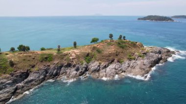 Mavi okyanus yüzeyindeki deniz taşlarının tepesindeki drone kameraları. Turkuaz deniz yüzeyindeki inanılmaz deniz dalgaları kayalara çarpıyor. Hava aracı 4k yüksekliğindeki Phuket Tayland 'daki okyanus kalitesi.