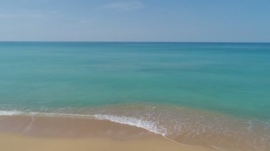 Deniz yüzeyinin üst görüntüsü dalgalar okyanusa köpürerek ve su sıçratarak çarpıyor. Sunny Day yaz arkaplanı yüksek kaliteli görüntüler. Phuket Denizi Tayland