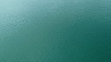 Deniz yüzeyinin üst görüntüsü dalgalar okyanusa köpürerek ve su sıçratarak çarpıyor. Sunny Day yaz arkaplanı Yüksek kaliteli görüntüler