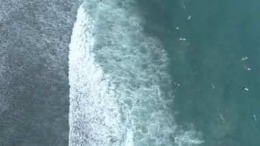 İnanılmaz hava manzarası. Dalgaların tepesi tropikal deniz sörfçülerinde kırılıyor. Sörf tahtalarıyla.