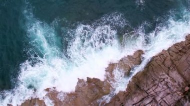 Hava dalgaları kayalık kayalıklara çarpıyor. Su sıçraması ve beyaz köpükle. Phuket Adası Tayland Yüksek Açılı Manzarası 'nda güzel dalgalar
