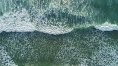 Deniz yüzeyinin üst görüntüsü dalgalar okyanusa köpürerek ve su sıçratarak ağır çekimde çarpıyor. Sunny Day yaz arkaplanı yüksek kaliteli görüntüler. Phuket Denizi Tayland