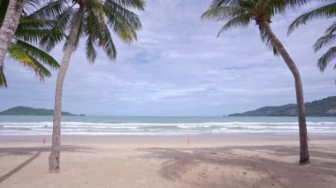Yaz denizi arkaplanı. Okyanus dalgaları üzerine mavi gökyüzü beyaz bulutlar. Dalgalar boş bir sahile çarpıyor. Patong Phuket Tayland 'da deniz dalgaları ve güzel kumsallar. Yüksek kaliteli video