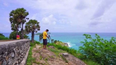 Phuket 'te Sunset' i görmek için Landmark 'ın ünlü turist beldesi Phuket Thailand' da, Laem Promthep Burnu 'nda manzara manzarası çeken Aynasız Kamera' yı ayarlayan profesyonel bir adam.