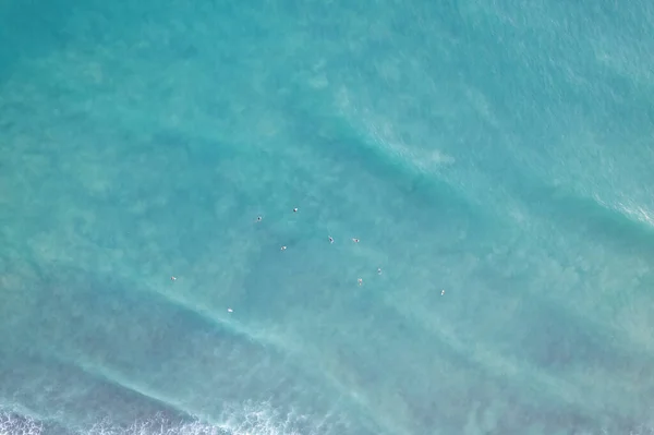 Amazing aerial view Top down of waves break on tropical sea Surfers with surfing boards Aerial drone view of sea waves on the beautiful ocean at Phuket Thailand