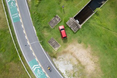 Kırmızı SUV arabasının ve asfalt eğrisinin yukarıdan yukarıdan görünüşü