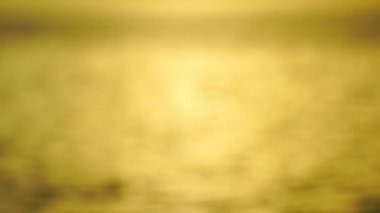 Bokeh güneşi, gün batımının su yüzeyindeki gündoğumu ışığının parlak yansıması. Okyanusta parıldayan güneş ışınları. Güneş 'te parıldayan altın deniz dalgaları. Odak dışı bulanıklık.