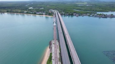 Aerial view drone shot of Amazing bridge with cars on bridge road. Transportation and travel background. Located at Sarasin bridge in Phuket Thailand