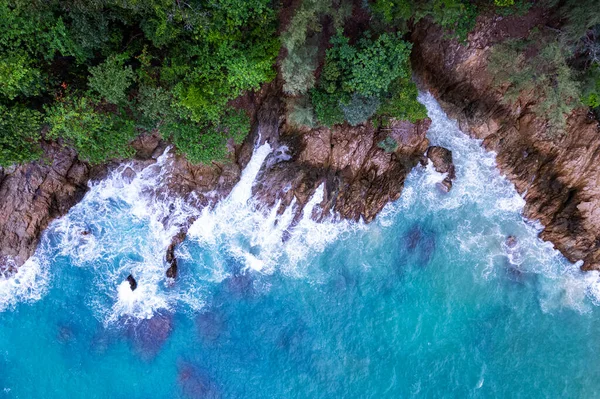 Aerial view Top down seashore big wave crashing on rock cliff Beautiful sea surface in sunny day summer background Amazing seascape top view seacoast at Phuket Thailand