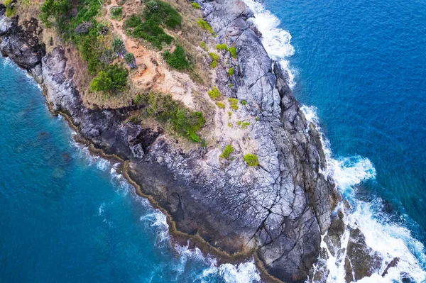 Aerial view Top down seashore big wave crashing on rock cliff Beautiful sea surface in sunny day summer background Amazing seascape top view seacoast at Phuket Thailand