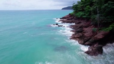 Phuket Okyanusu 'ndaki deniz kıyısı kayaları kayalara çarpıyor. Uçurum deniz manzaralı insansız hava aracı kamerası. İnsansız hava aracı kamerası Phuket Adası sahil şeridinden yüksek kaliteli görüntüler.