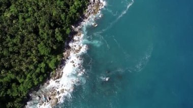 Aerial view Top down seashore big wave crashing on rock cliff, Beautiful dark sea surface in sunny day summer background, Amazing seascape top view seacoast,High quality footage