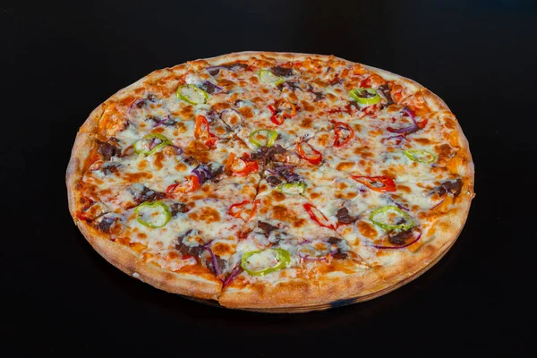 Siyah arka planda et ve sebzeli yakın plan pizza.