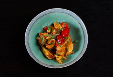 Siyah arka planda kızarmış kabaklı salata.