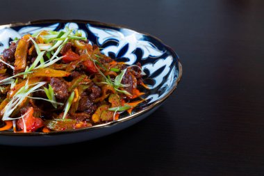 Siyah arka planda doğranmış et ve sebze tabağı. Asya mutfağı