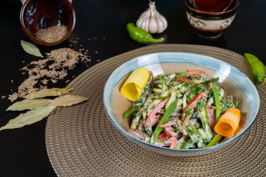 Sebzeli salata, tavuk ve mayonez manzaralı siyah bir arka plan.