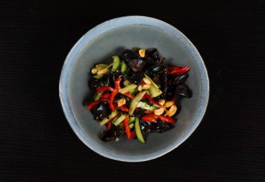 Fıstıklı siyah Muer mantarı, doğranmış salatalık, kırmızı dolmalık biber ve sos. Vejetaryen yemeği.