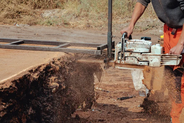 Tahta yapmak için ağaç gövdesini elektrikli testereyle kesen oduncunun yakın çekimi.