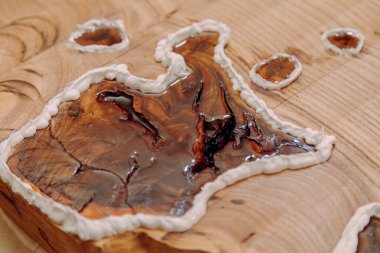 Ahşap masada kurumuş epoksi reçineye yakın çekim. El yapımı reçine ve ahşap masa.