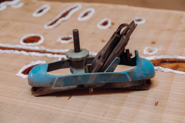 Eski metalik eklem düzlemi ahşap masanın üzerinde yatıyor. Ahşap masa üzerinde ahşap işçiliği aletleri. Marangozluk atölyesi