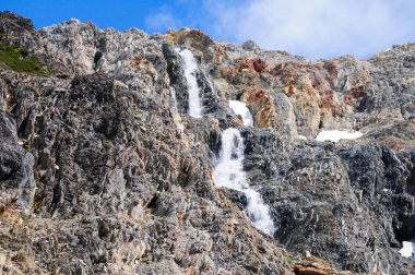 Kayalık dağların arasında akan şelale