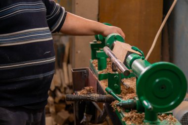 Marangoz torna tezgahına odun koymaya hazırlanıyor.